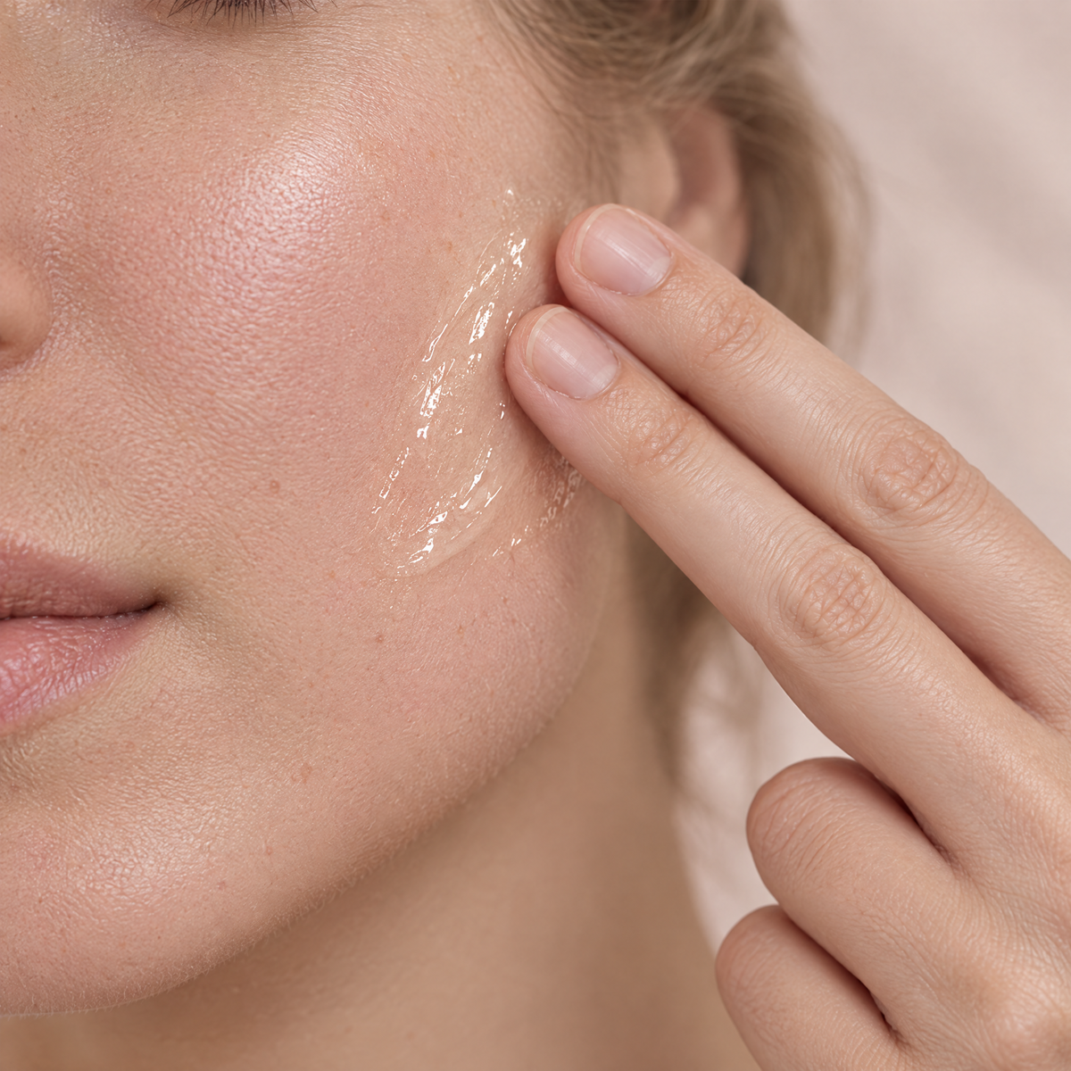 Anwendung der Skéina Anti-Redness Essence: Fingerkuppen verteilen das klare Serum-Gel sanft auf empfindlicher Wange